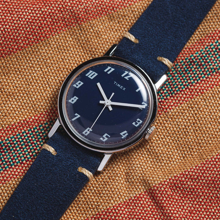 flatlay of the 1976 Timex Mercury Blue, on a striped background
