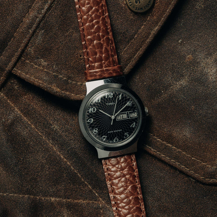 flatlay of the 1977 Timex Marlin against a suede jacket