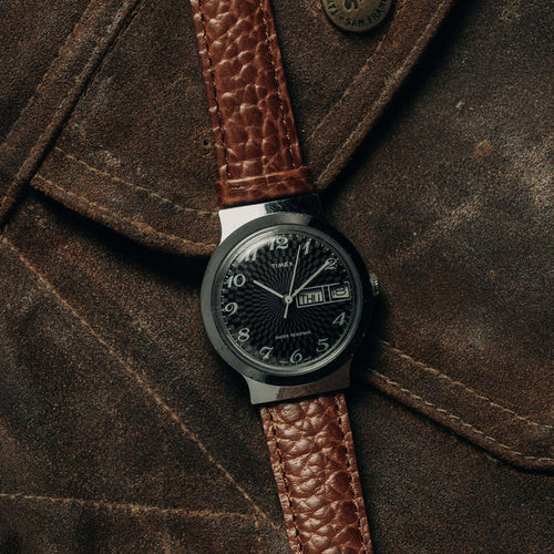 flatlay of the 1977 Timex Marlin against a suede jacket