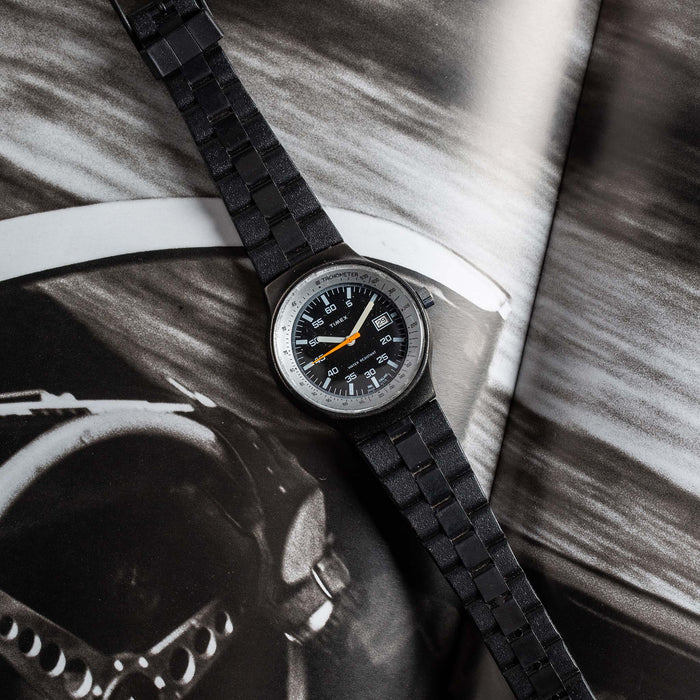flatlay of the 1978 Timex Black Max, shown against a magazine
