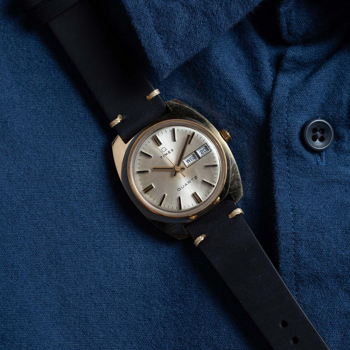 flatlay of the 1978 Timex Q Quartz against a blue shirt