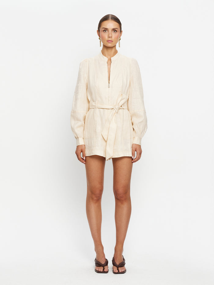 Woman wearing a cream-colored outfit on a white background