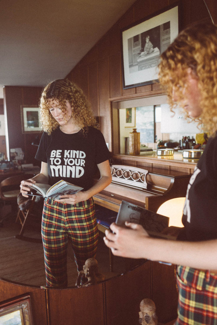 Woman stood reading a book wearing Be Kind to Your Mind Fitted Crewneck by The Bee and The Fox