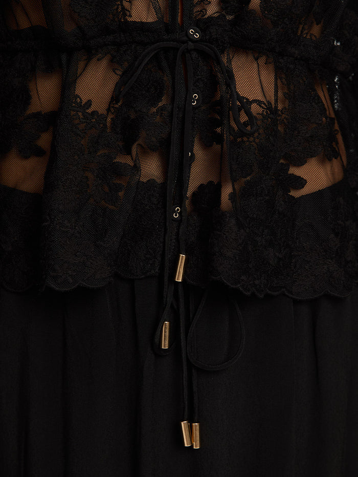Close up image of lace top and black skirt  with tie up details