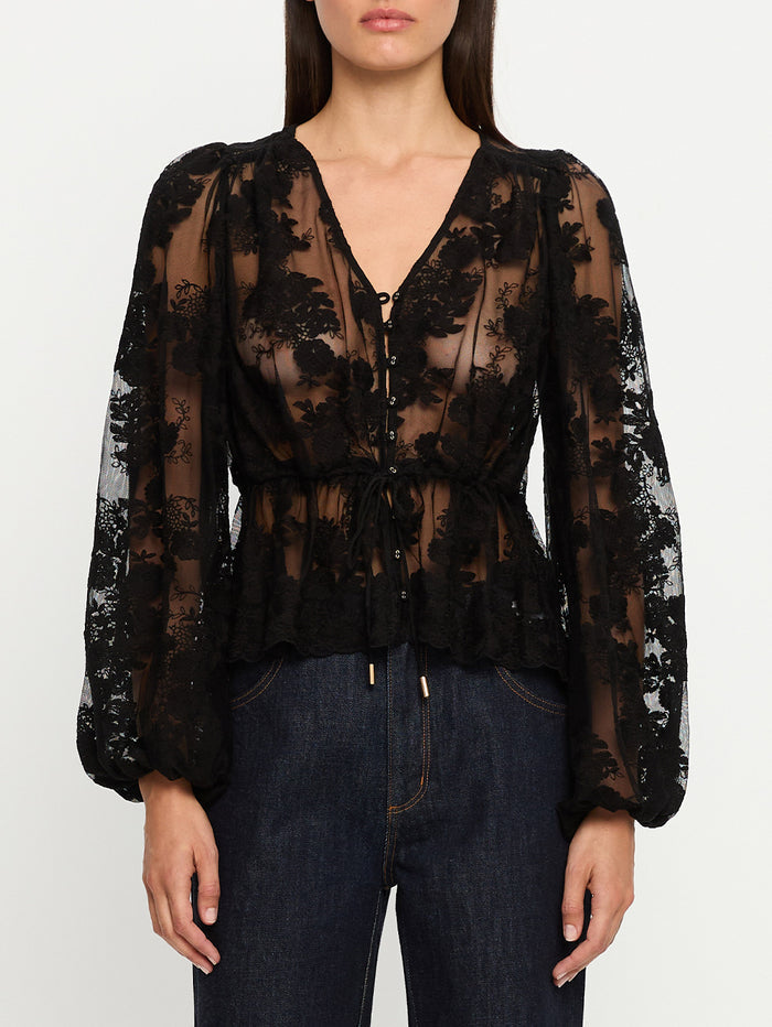 Black lace blouse worn by a person on a white background