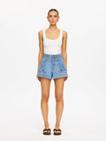 Woman wearing a white tank top and blue denim shorts on a white background