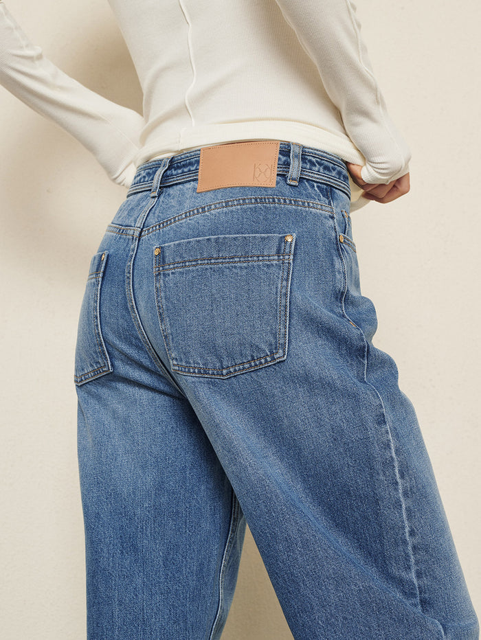KIVARI Dylan Jeans in Blue – close-up back pocket detail styled with a cream knit sweater