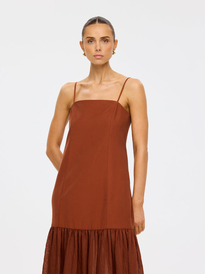 KIVARI Elanor Maxi Dress in Hazel – three-quarter view of model wearing women's hazel spaghetti strap tiered maxi dress with gold earrings