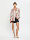 Woman wearing a striped shirt and black shorts on a white background
