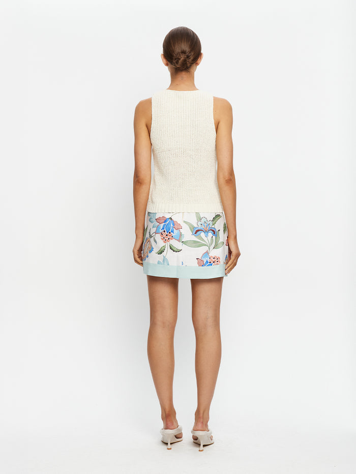 Woman wearing a sleeveless dress with floral pattern on a white background