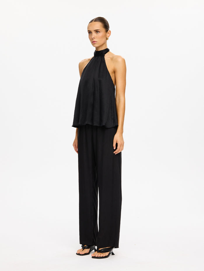 KIVARI Jaxon Halter Top in Black – full-length side view of model wearing women's black halter neck top with wide-leg pants and strappy heels