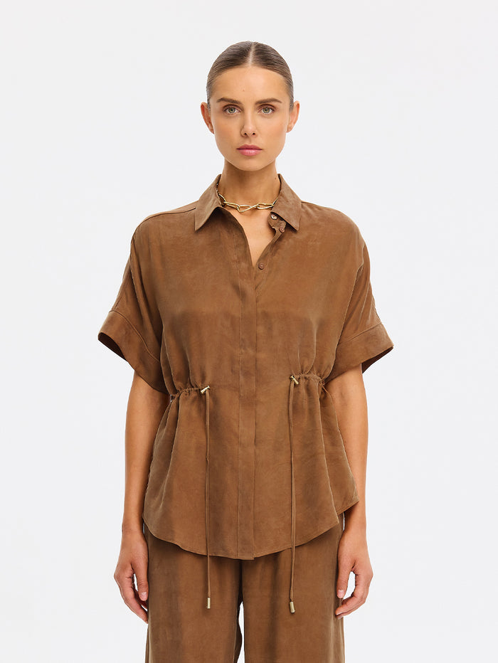 Woman wearing a brown outfit on a white background