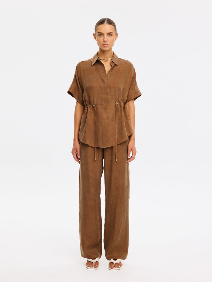 Woman wearing a brown outfit on a white background