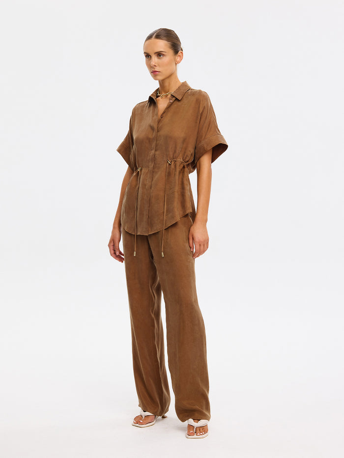 Woman wearing a brown outfit on a white background