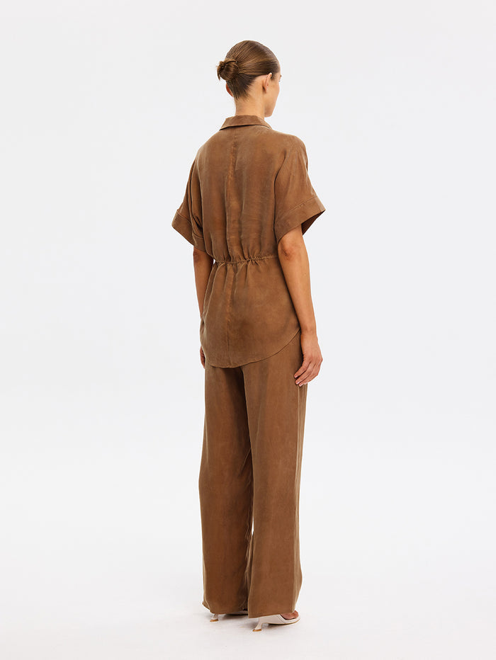 Person wearing a brown outfit on a white background
