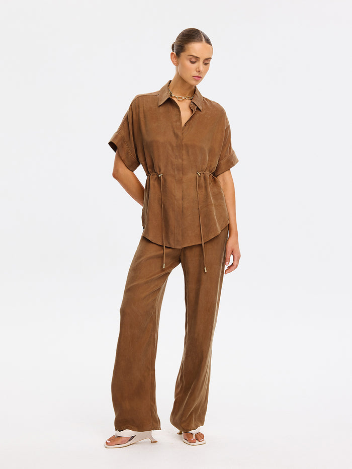 Woman wearing a brown outfit on a white background