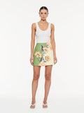 Lotte Mini Skirt in Green Cream, front view of A-line mini skirt with floral print and white tank top