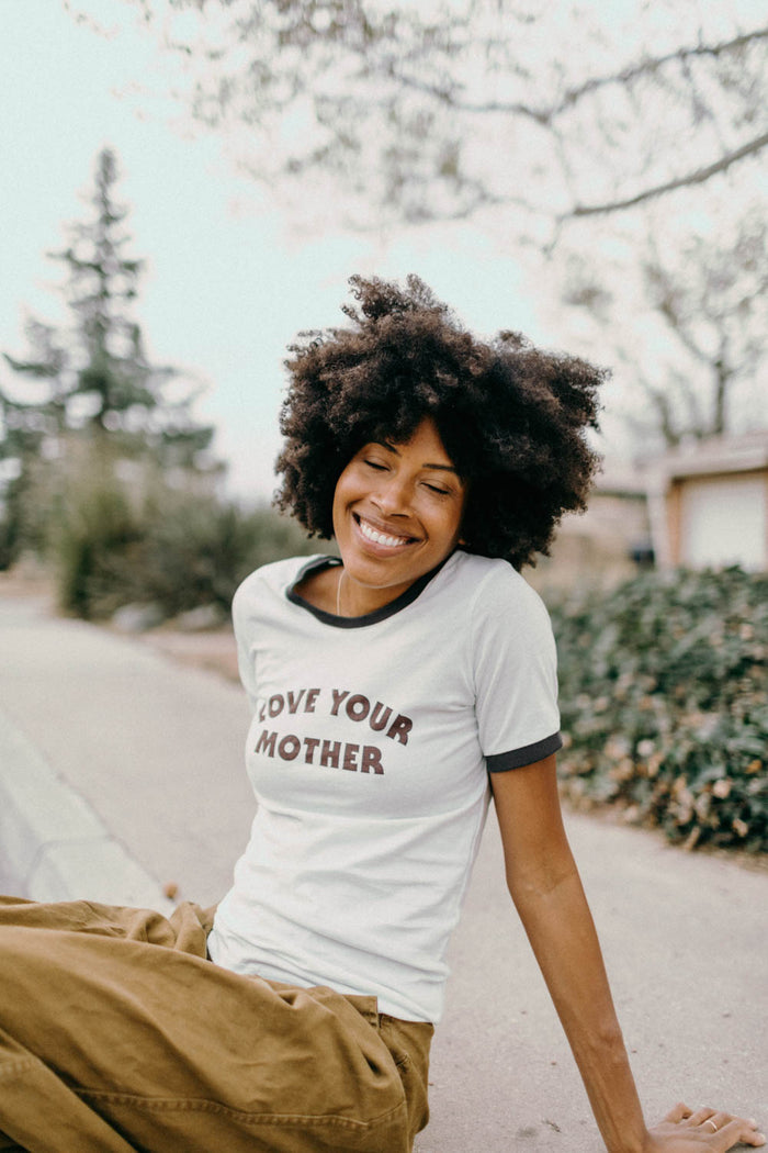 Woman sat on curb wearing Love Your Mother Ringer Tee for Women by The Bee and The Fox