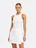 Woman wearing a white dress with lace details on a white background