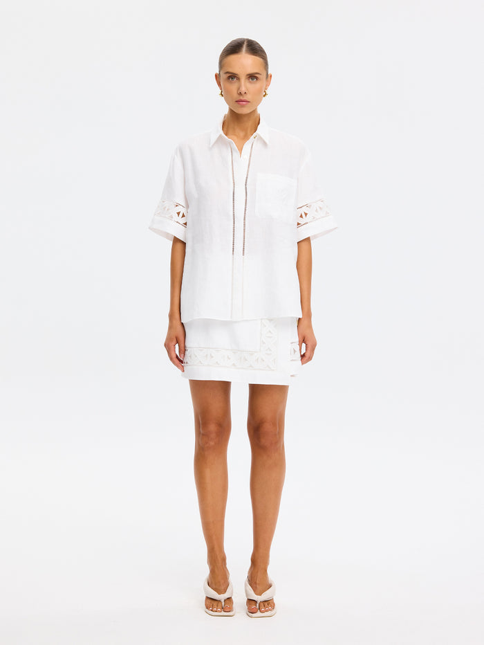 Woman wearing a white outfit on a plain background