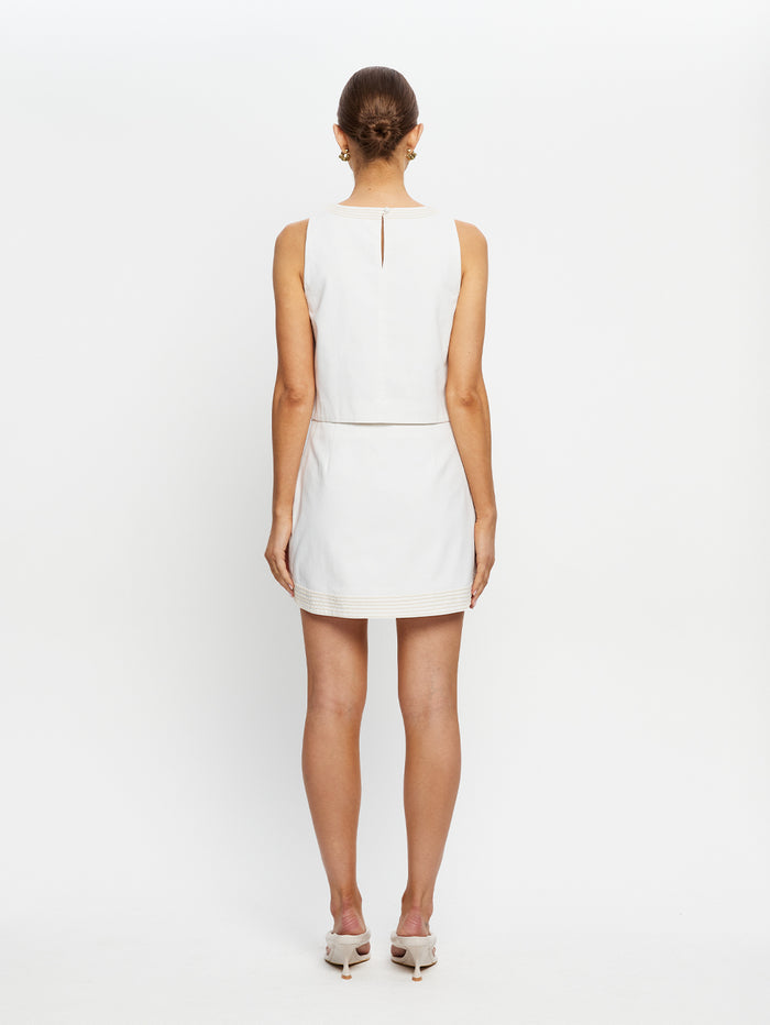 Woman wearing a white dress on a plain background