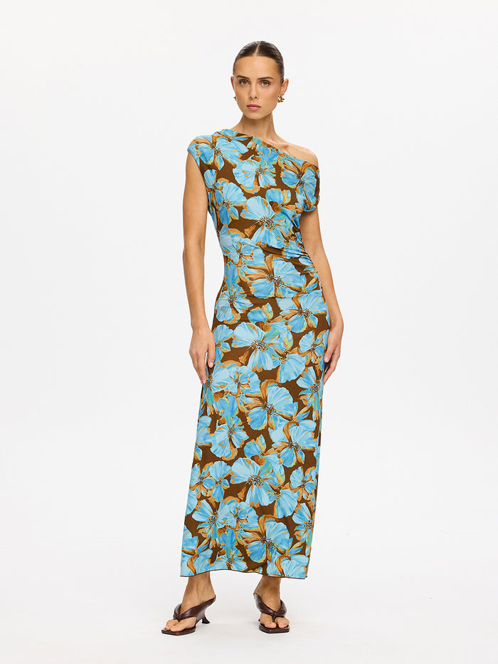KIVARI Nieve Jersey Maxi Dress in Blue - 3/4 angled view of model wearing blue and brown floral one-shoulder jersey maxi dress