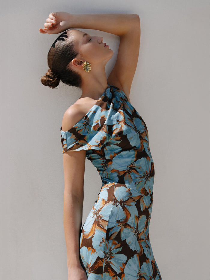 KIVARI Nieve Jersey Maxi Dress in Blue Floral Print – Mexico campaign editorial shot of model in dramatic pose wearing women's one-shoulder floral jersey maxi dress