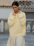 Woman wearing a light yellow sweater and skirt in an outdoor setting