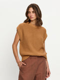 Woman wearing a brown knitted sleeveless top and brown pants on a white background