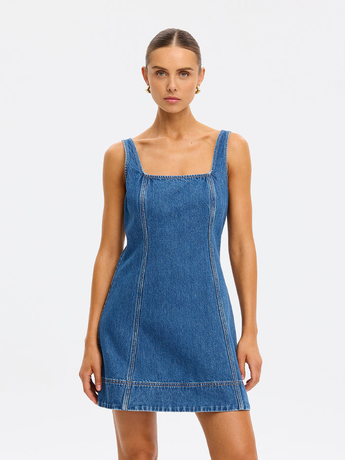 Woman wearing a blue denim dress on a white background