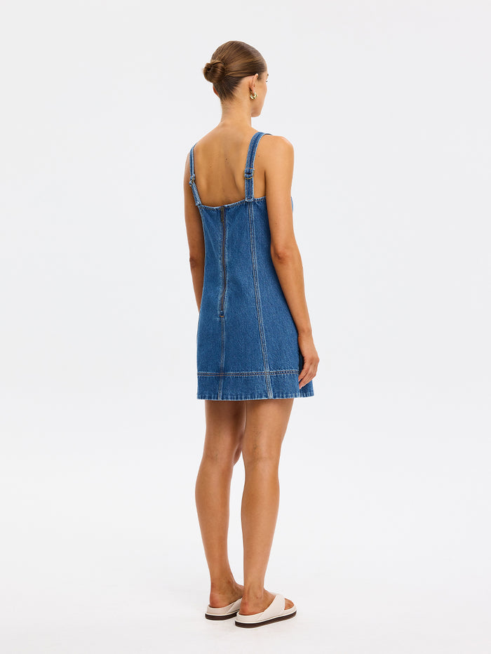 Woman wearing a blue denim dress on a white background