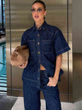 Woman in a denim outfit holding a brown bag in an indoor setting.