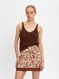 Woman wearing a brown tank top and leopard print skirt on a white background