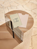 KIVARI physical gift cards in sage green and blush pink on a marble pedestal