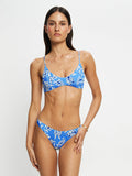 Woman wearing a blue floral bikini against a white background
