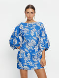 Woman wearing a blue floral dress on a white background