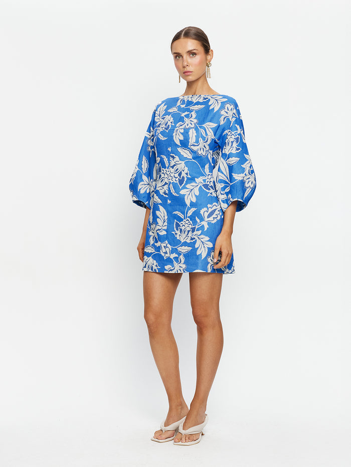 Woman wearing a blue floral dress on a white background