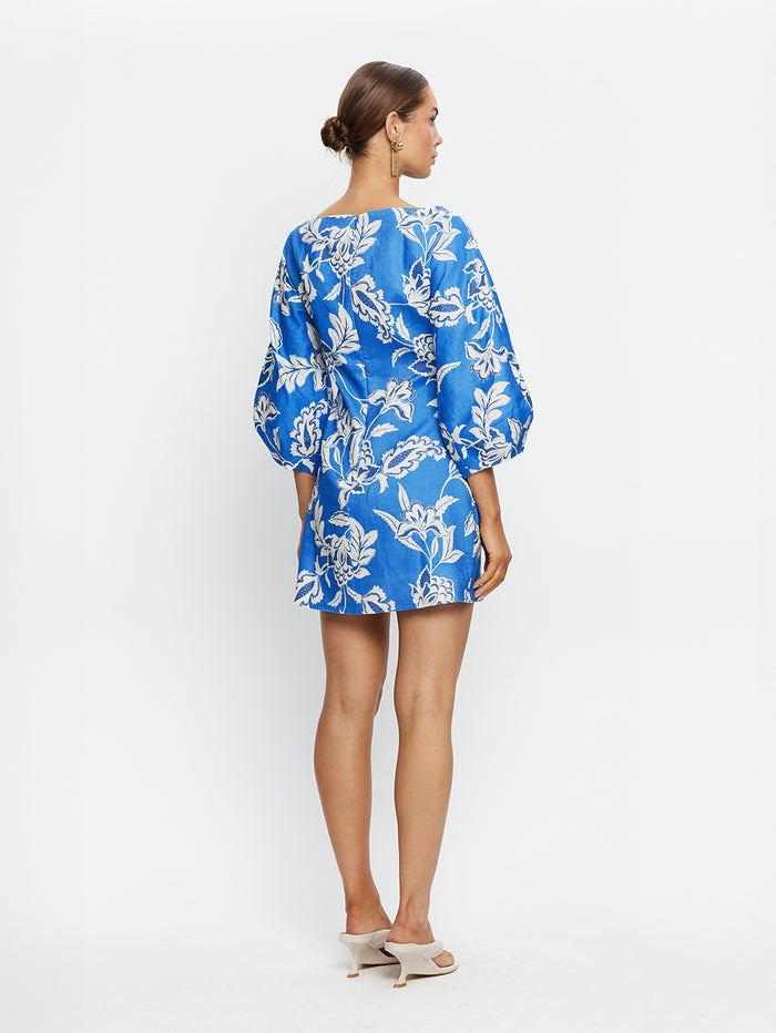 Woman wearing a blue floral dress on a white background