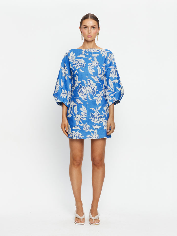 Woman wearing a blue floral dress on a white background