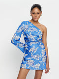 Woman wearing a blue floral one-shoulder dress on a white background