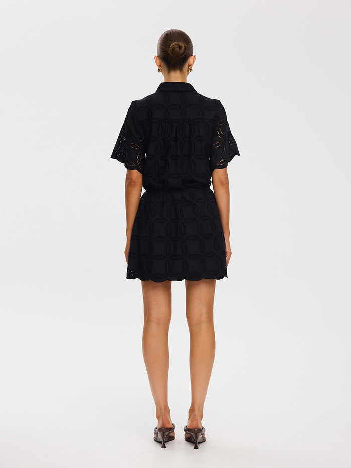 Person wearing a black lace dress on a white background