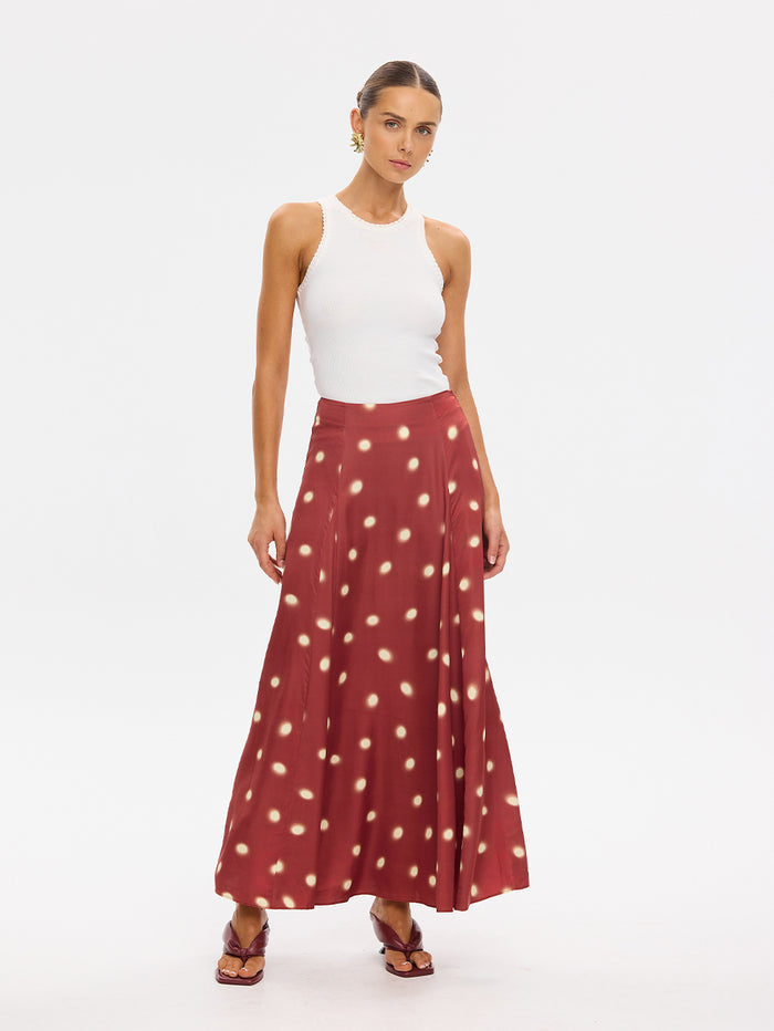 KIVARI Saro Maxi Skirt in Brick – polka dot maxi skirt styled with a white tank top, front view
