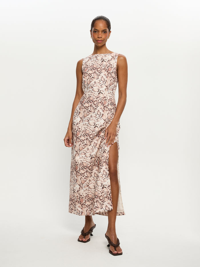 Woman wearing a snake print dress with a slit on a white background