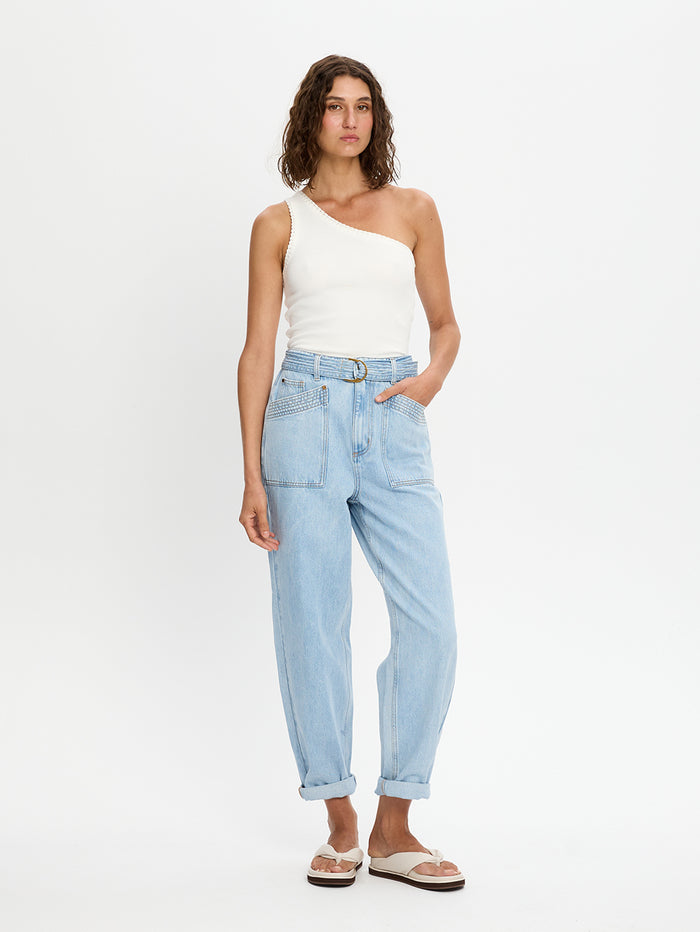 Woman wearing a white top and light blue jeans on a white background