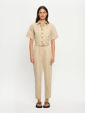 Woman wearing a beige jumpsuit on a white background