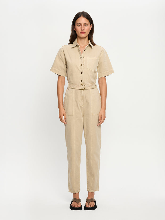 Woman wearing a beige jumpsuit on a white background