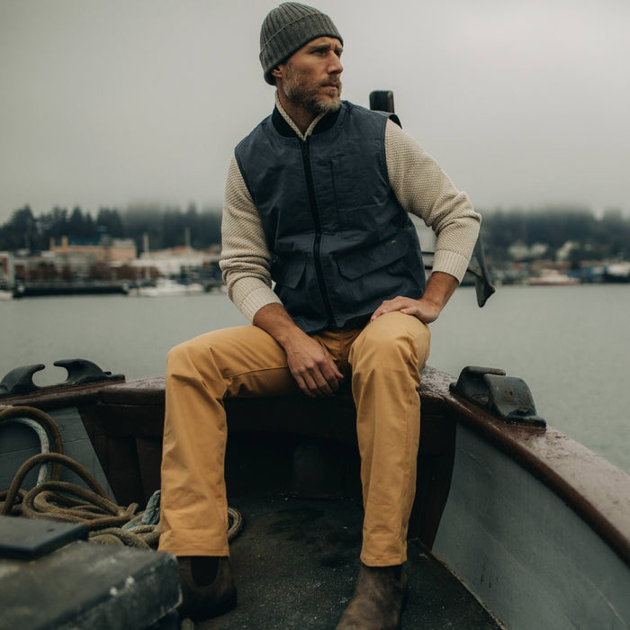 fit model wearing The Anchorage Vest in Charcoal Dry Wax on a boat