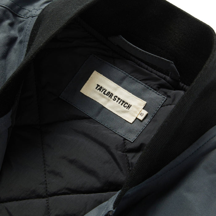 material shot showing interior label of The Anchorage Vest in Charcoal Dry Wax