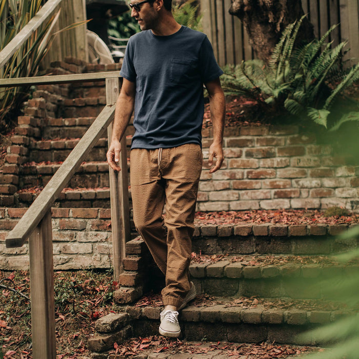 our fit model wearing The Après Pant in British Khaki Seersucker—walking down stairs