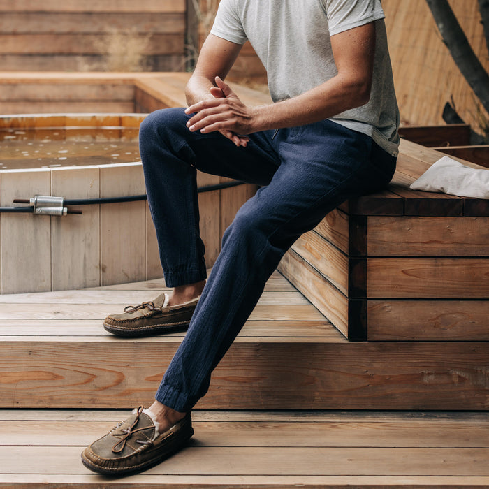 fit model sitting in The Apres Pant in Charcoal Double Cloth